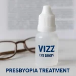 VIZZ eye drops bottle with reading glasses on blurred text, symbolizing presbyopia treatment and clear near vision.